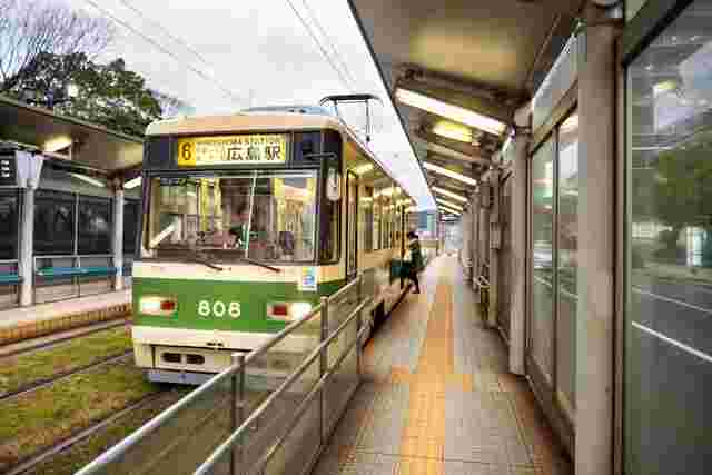 A tram sitting at a stop in Hiroshima, Japan