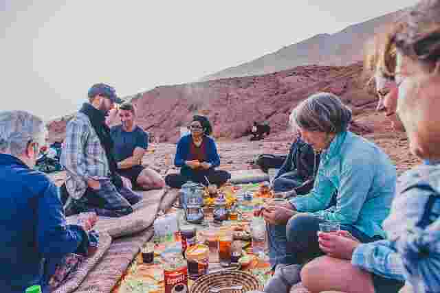 A group of travellers enjoying traditional Moroccan food in a Berber community in Morocco