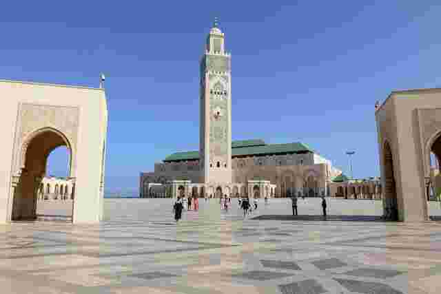 The imposing structure of the Hassan II Mosque against a blue sky backdrop.