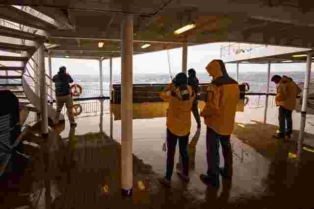 A handful of travellers standing on the deck of the Ocean Endeavour while crossing the Drake Passage.