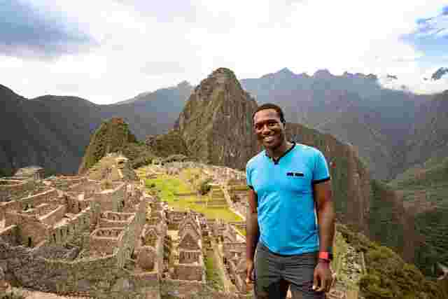 Man standing in front of the ruins of Machu Pichu 