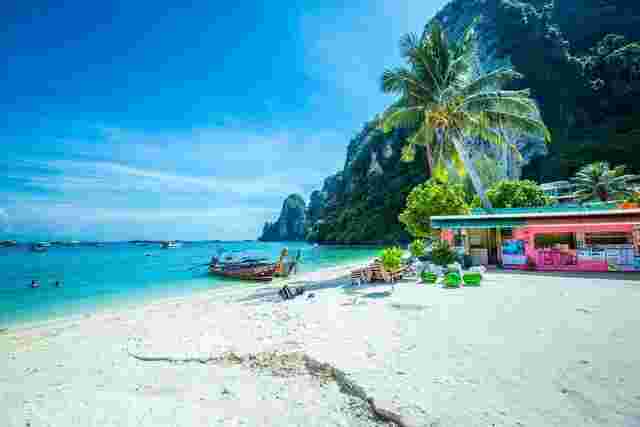 A beach with white sand and turquoise water on the Phi Phi Islands, Thailand 