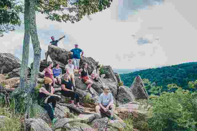 A group of travelers sitting on a bunch of rocks along the Appalachian Trail in North Carolina