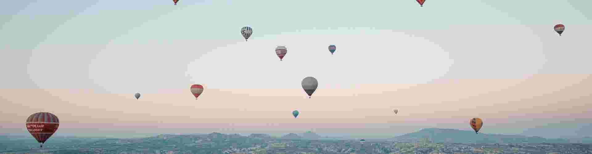 A collection of hot air balloons flying at sunrise in Cappadocia, Turkey