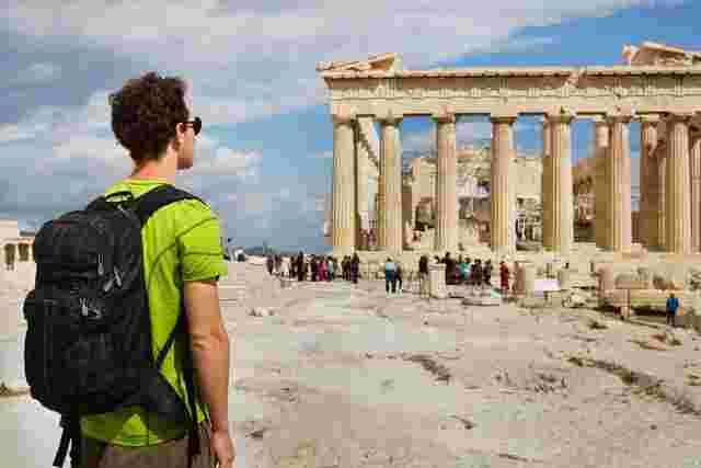 A traveler stands in front of the Parthenon in Athens