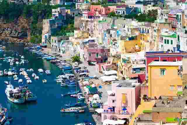 A collection of pastel colored buildings on the coast of Naples in Italy 