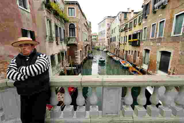 A local gondola skipper standing on a bridge in Venice 