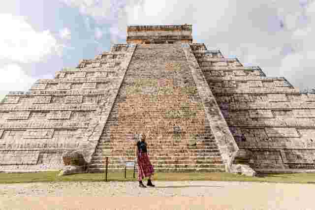 A traveler standing at the base of Chichen Itza in Mexico
