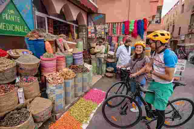Two travellers stopping by a market in Marrakesh on their bicycles