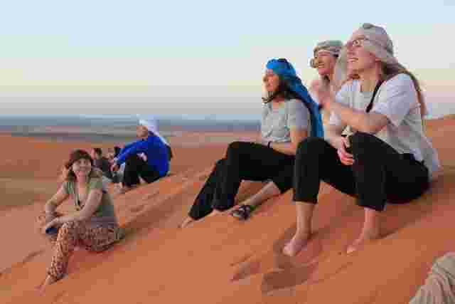 A group of traveller admiring the sunset in the Sahara Desert