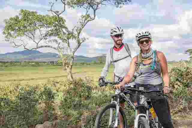 Two cyclists posing for a photo in the Serengeti, Tanzania