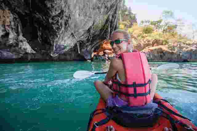Traveller looking back at the camera in a kayak in Thailand