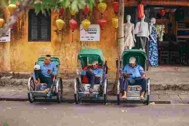 A row of local men and their auto rickshaws in Hoi An. 