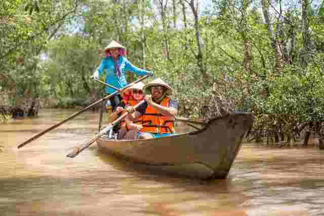 A group of travelers on a rowing boat along the Mekong in Vietnam