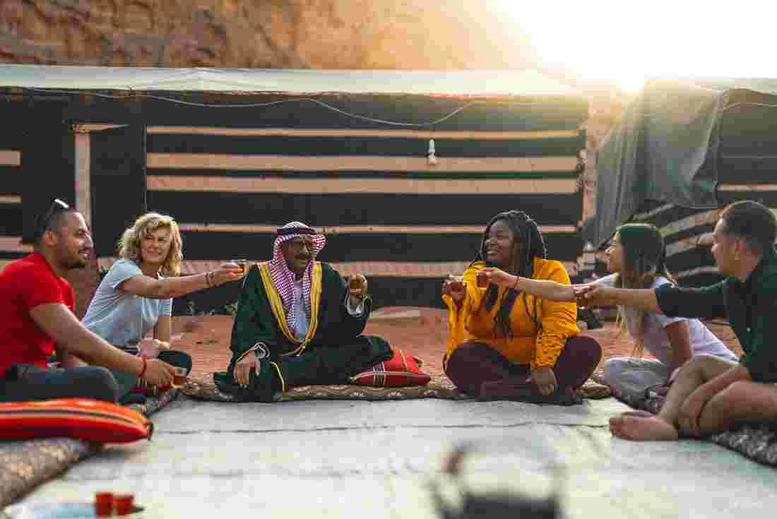 Small group of travellers enjoy a drink in Bedouin camp