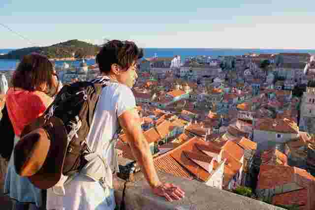 Two travelers admiring the sweeping views of Dubrovnik's Old Town from a tower