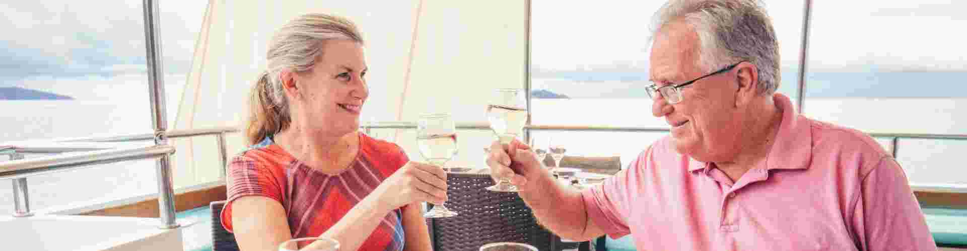 A couple raising a toast in cheers onboard a sailing boat in Thailand 