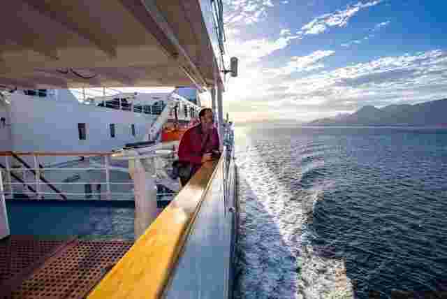 A man staring out at the calm waters of Drake Passage from aboard the Ocean Endeavour. 