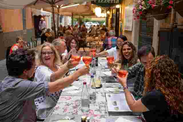 A group of travellers making a toast at dinner in Menaggio, Italy