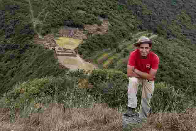 Man standing in front of the ruins of Machu Picchu in Peru 