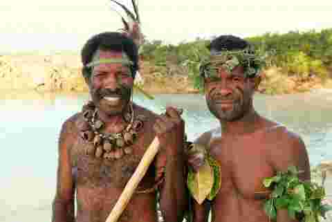 Two Vanuatu locals smiling at the camera in traditional dress 