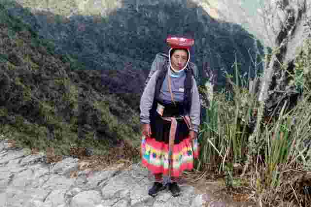 Local woman with a backpack on along the Inca Trail in Peru