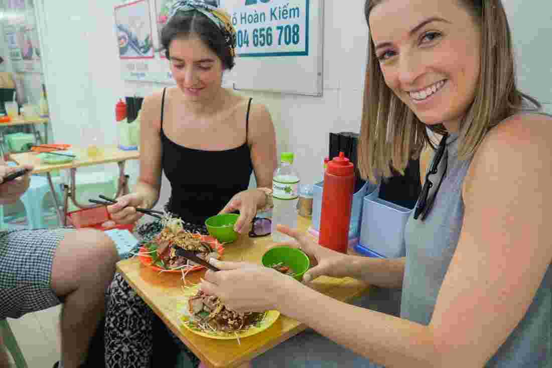 Two female travellers eating food in Vietnam