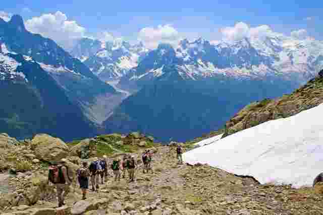 A group of travelers hiking along the Tour du Mont Blanc in France. 