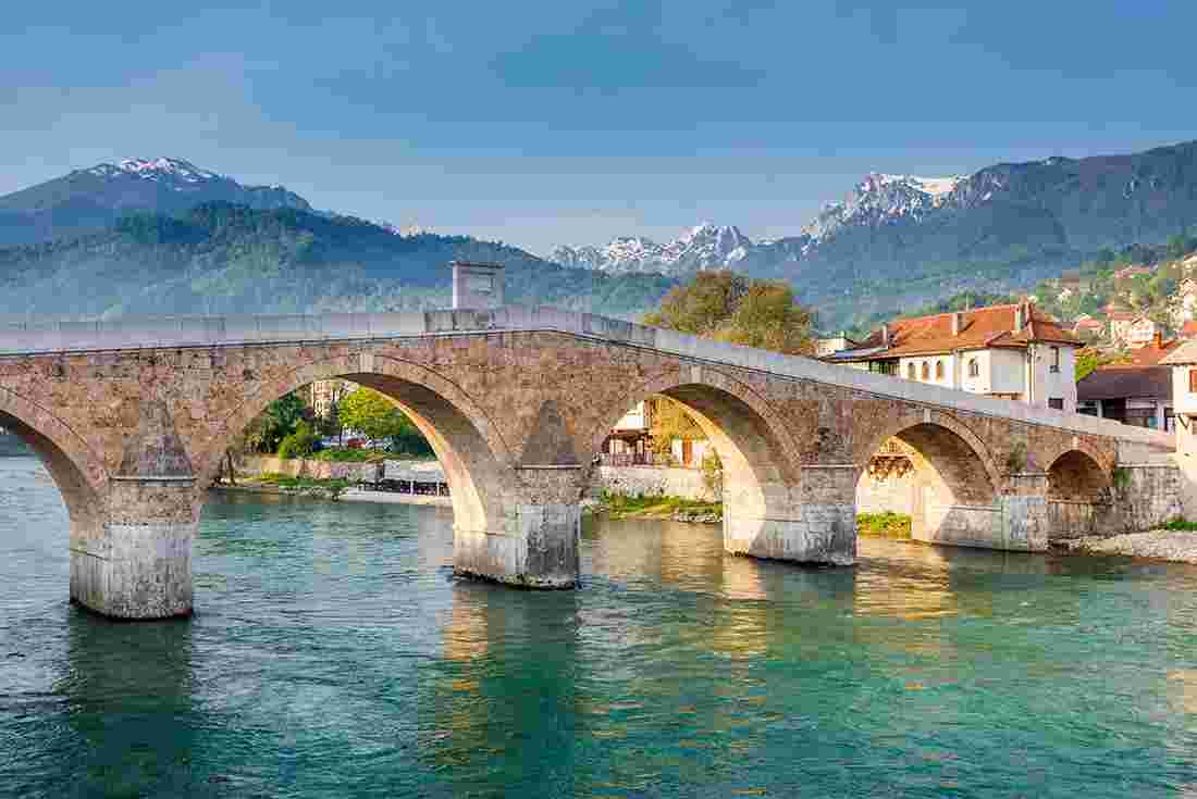 Gorgeous Konjic Bridge with town and mountains in the background, Bosnia & Herzegovina