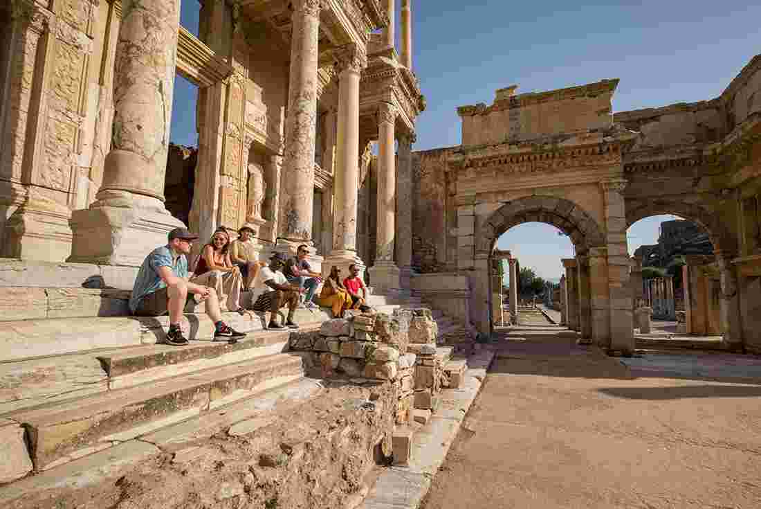 Intrepid group sitting down and enjoying the ruins of the Ancient Greek city of Ephesus, Turkey