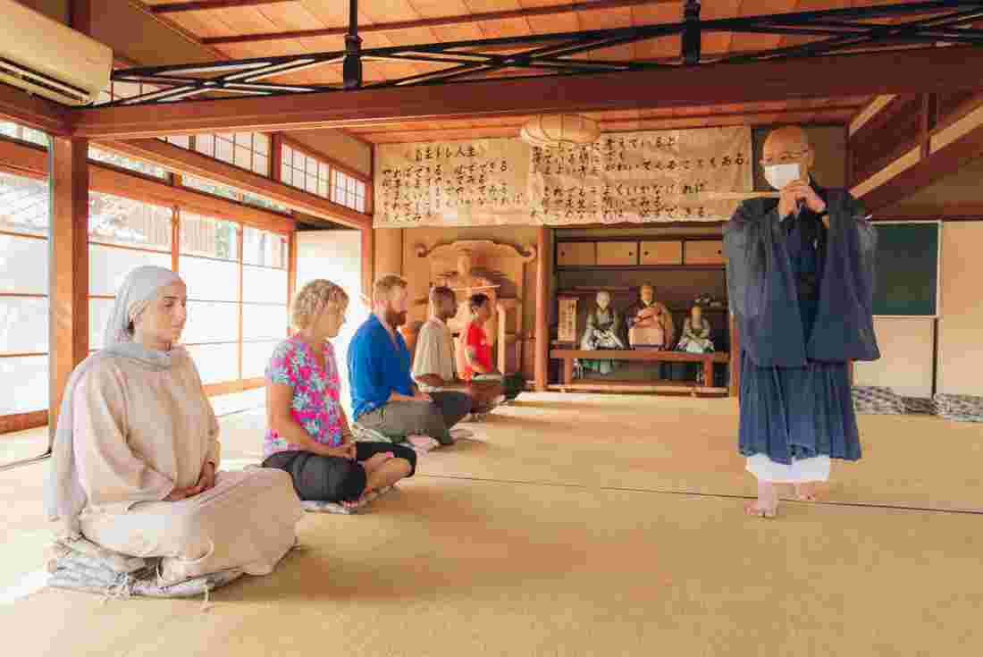 Group of Intrepid travellers is instructed in Zen Buddhist meditation by monk at Daitokuji Temple