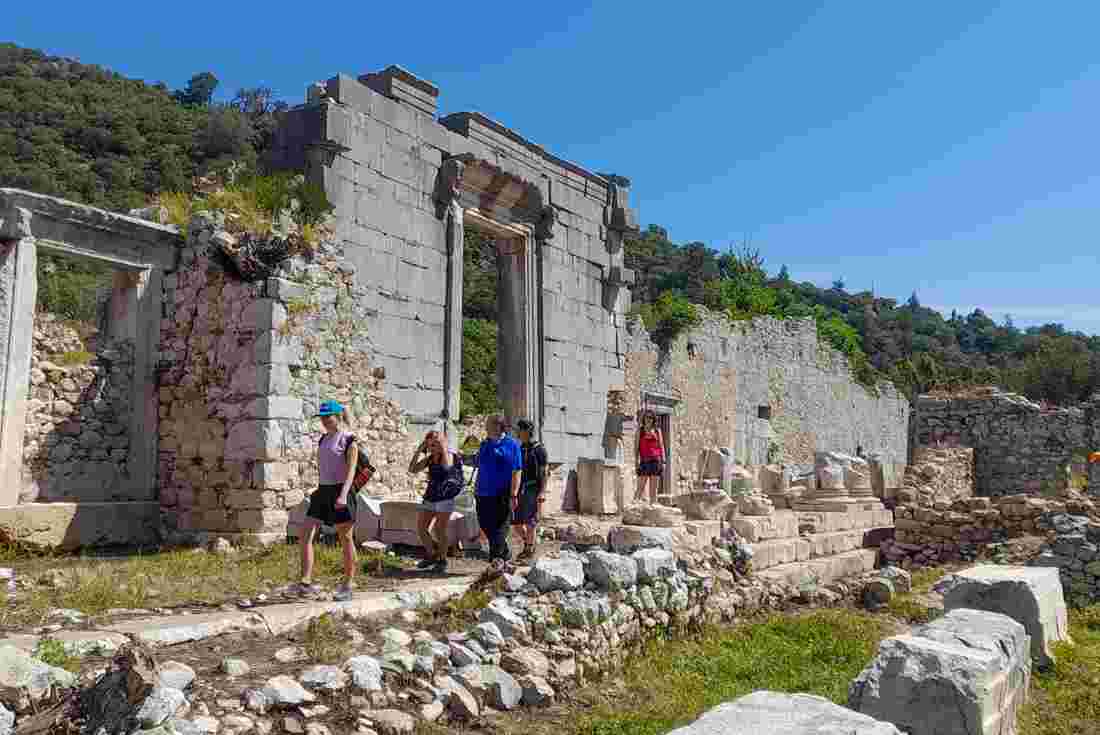 Intrepid travellers walk past ruins on the hike along the Lycian Way in Turkey