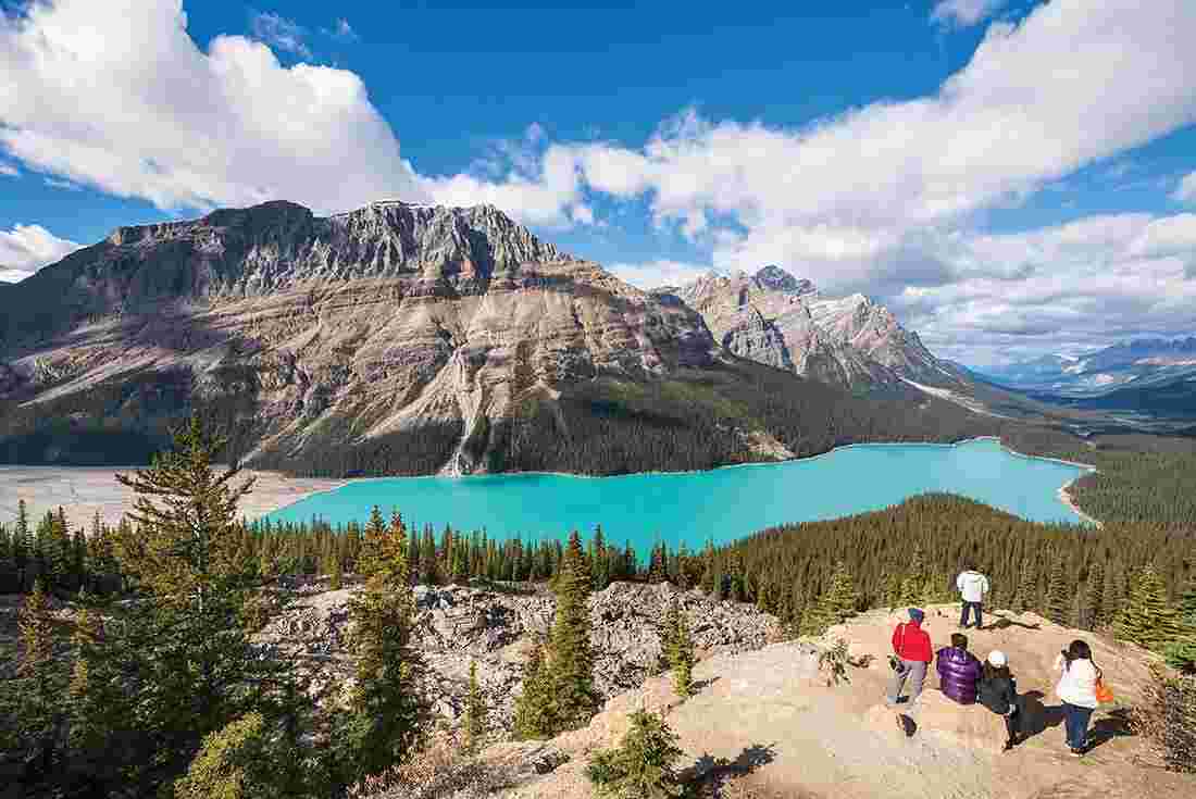 Group of travellers admiring Peyto lake and mountains in Calgary, Alberta 