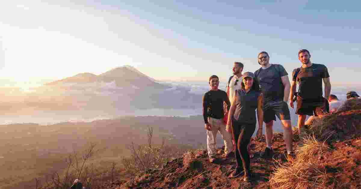 Group of travelers summit Mount Batur, Bali 