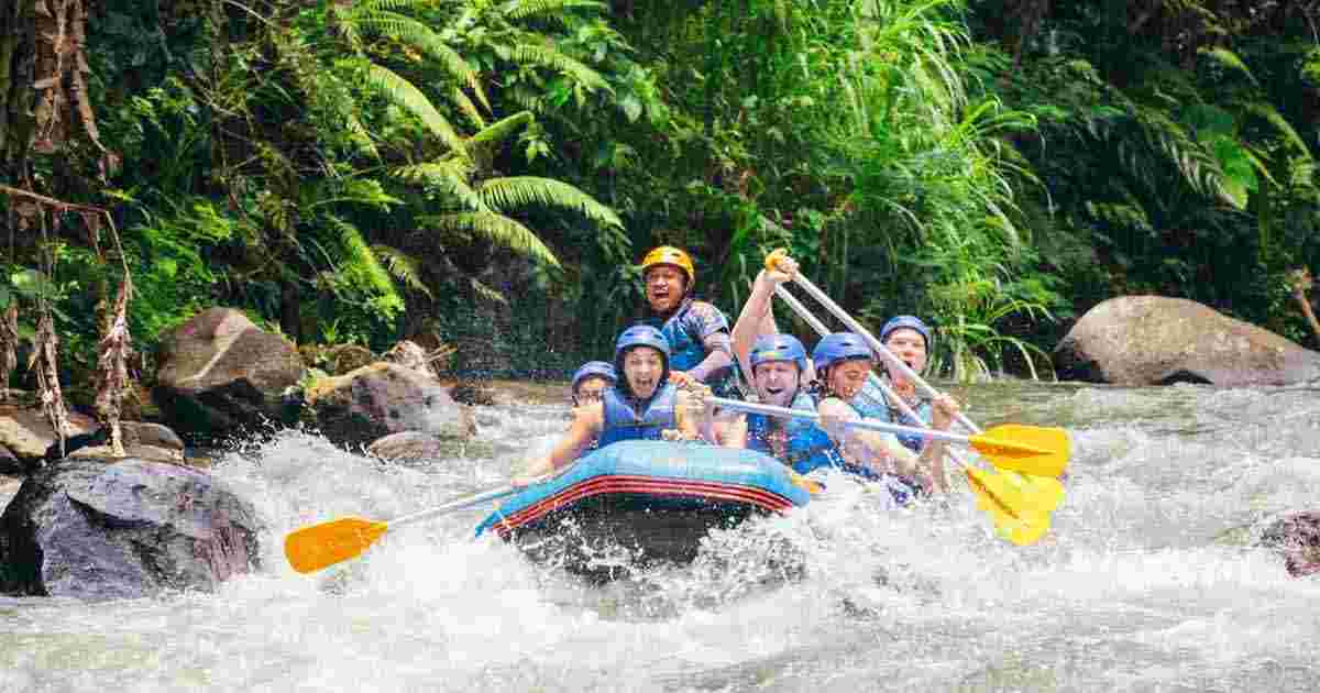 Group of travelers white water rafting down raging river in Ubud