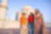 Senior and younger female travellers stand with Intrepid leader outside the Taj Mahal during the day