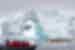 Zodiacs and kayaks marvel at an arched iceberg off the coast of Antarctica