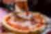 Traveller slices into fresh baked pizza in Pisa, western Italy
