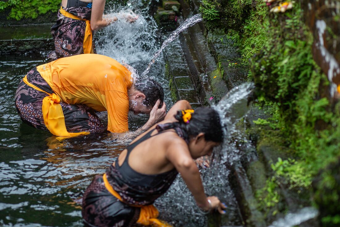 Travellers partake in a purification ceremony at Pura Gunung Kawi Sebatu, Ubud, Indonesia