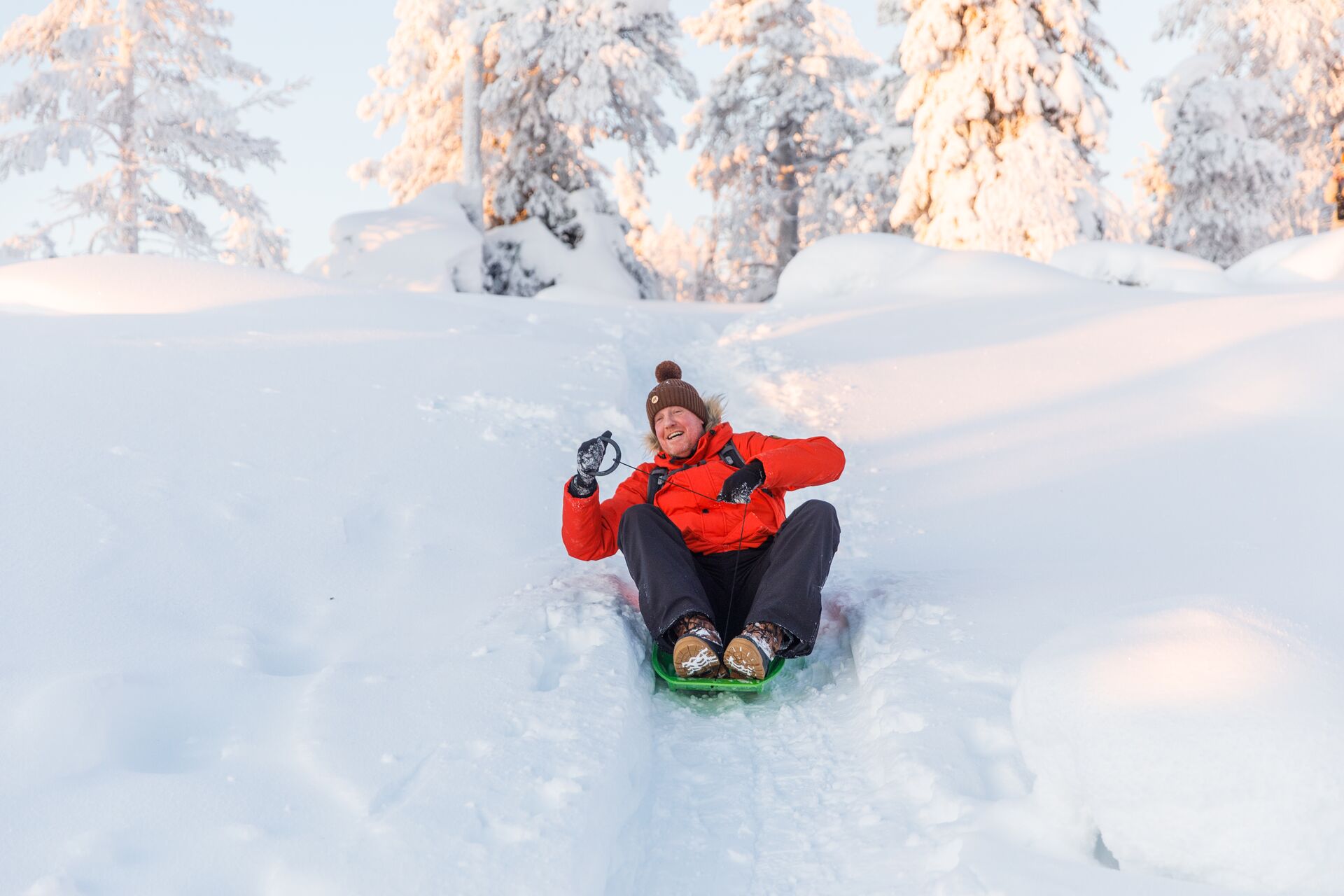 Tobagganing down a snow hilltop in Finland