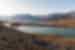 Distant travellers walk along a spit through a fjord in Ella Island landscape northeastern Greenland