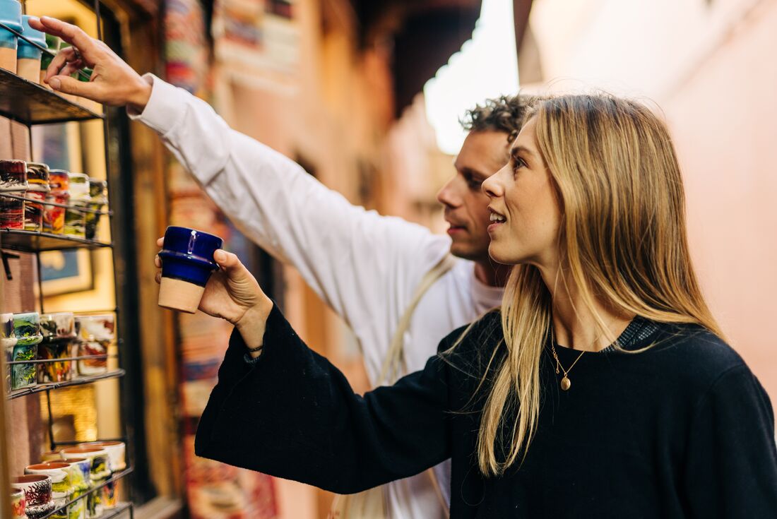 Young Intrepid travellers browse ceramics in a market in Marrakech, Morocco