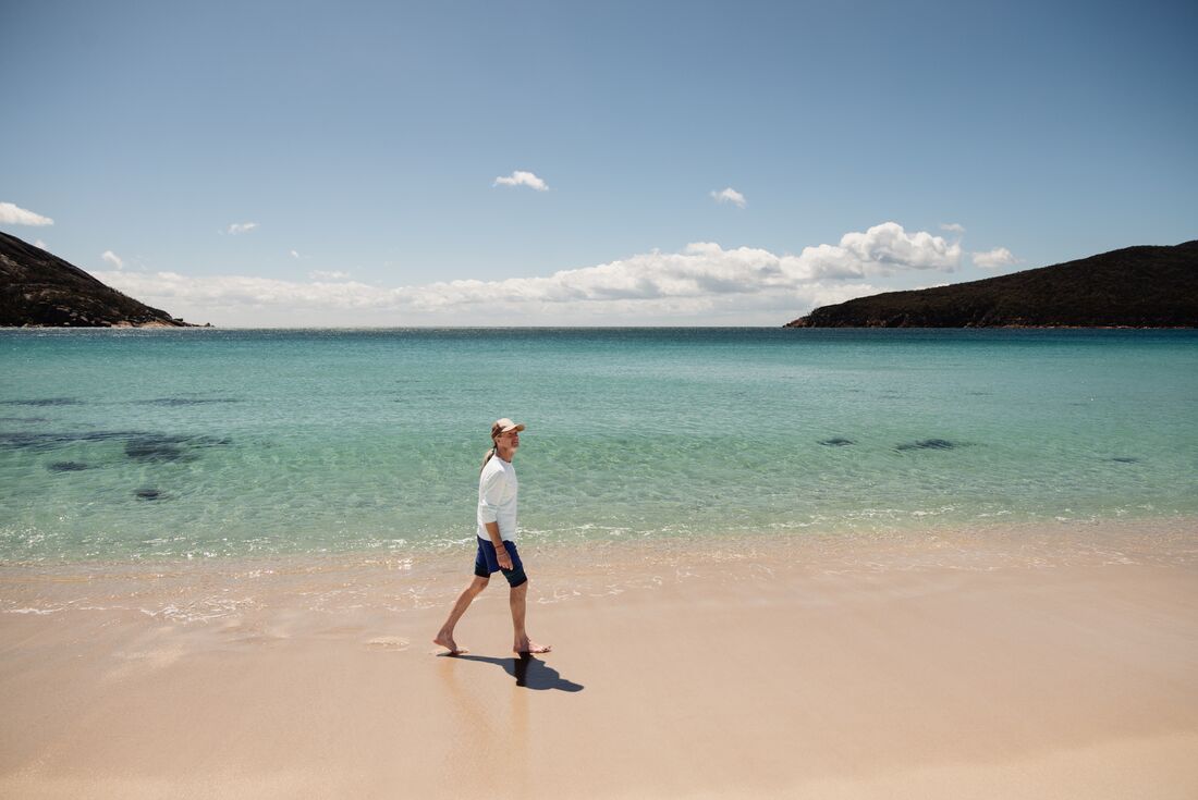 Traveller walking on the beach at Wineglass Bay in Tasmania, Australia