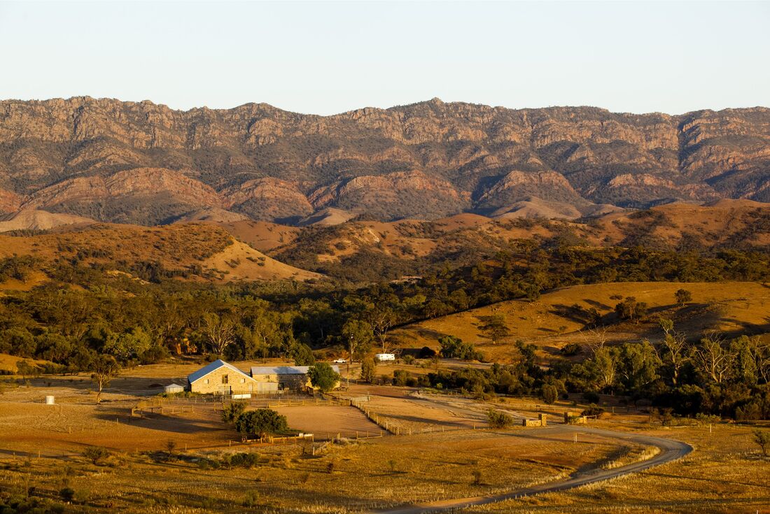 Aerial view of the woolshed accomodation facilities in vast, red landscape during sunset, South Australia