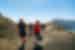 Intrepid leader and travellers hike the caldera ridge of Santorini with mountains visible beyond