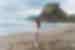 Traveller walking down Piha Beach with Lion Rock in the background in Auckland, New Zealand