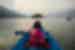 Traveller in lifejacket with paddle on a colourful rowboat on Pokhara Lake in Nepal
