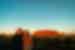 Intrepid travellers pose for a happy photo with Uluru hit by the sunset beyond