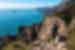 POV of traveller hiking high in the mountains in Praiano, Positano, Italy, looking out to the blue ocean and blue sky horizon