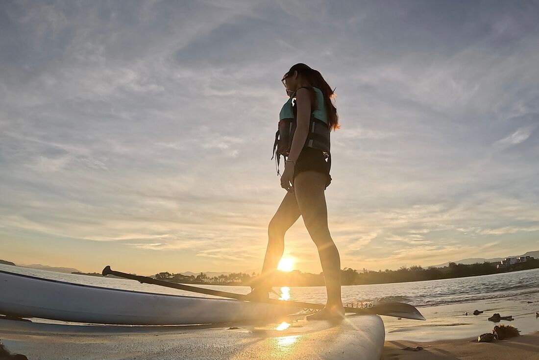Traveller with paddle board in Kota Kinabalu during sunset, Borneo